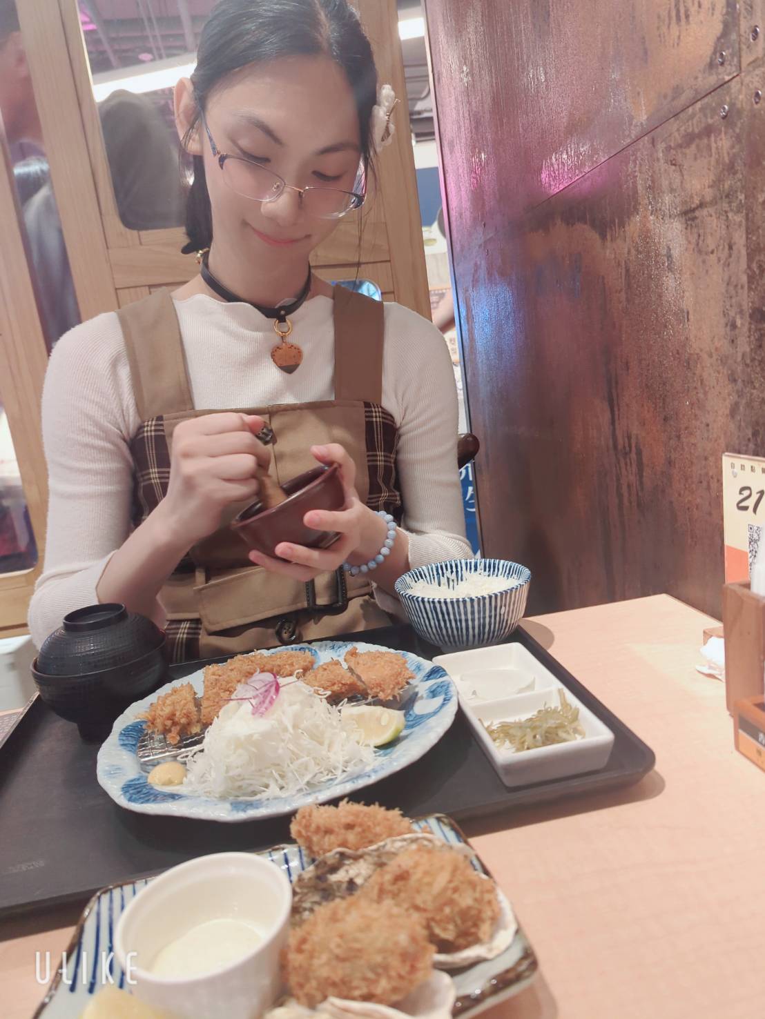 絵夢羽さ沂在餐廳裡拿著小碗、桌上擺著餐點的生活照